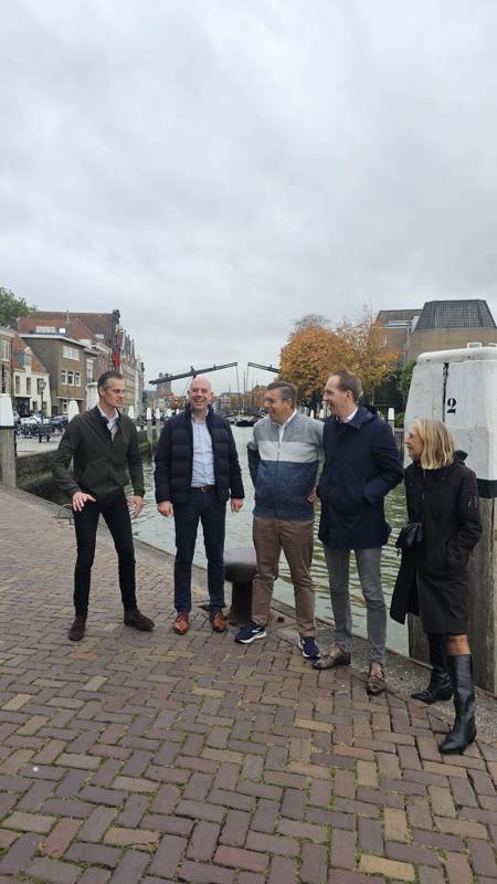Een groep op een kade met een ophaalbrug op de achtergrond