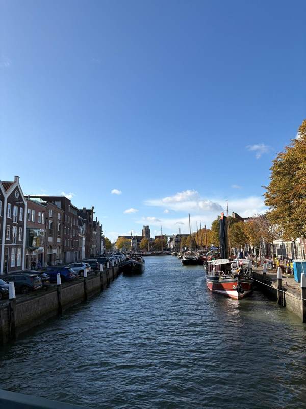 Een gracht met boten en herfstbomen in de oude binnenstad