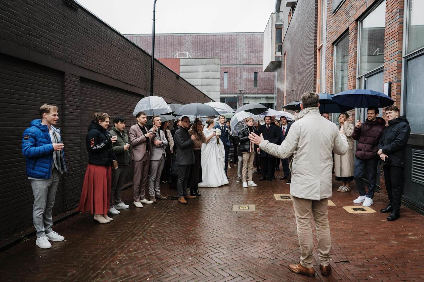 De gids met uitgestrekte armen voor een groep in een steeg